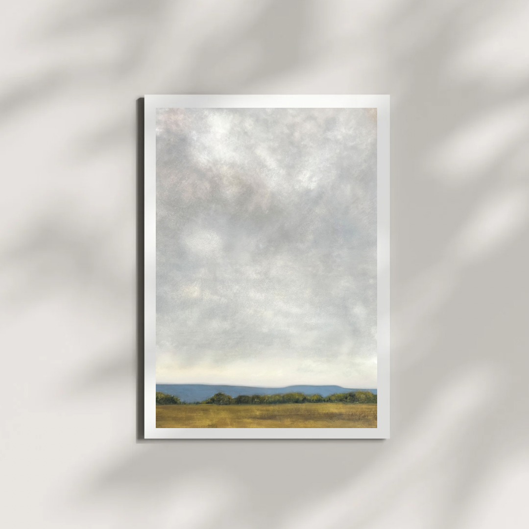 artwork of a landscape with a field and trees under a cloudy sky on a white wall.